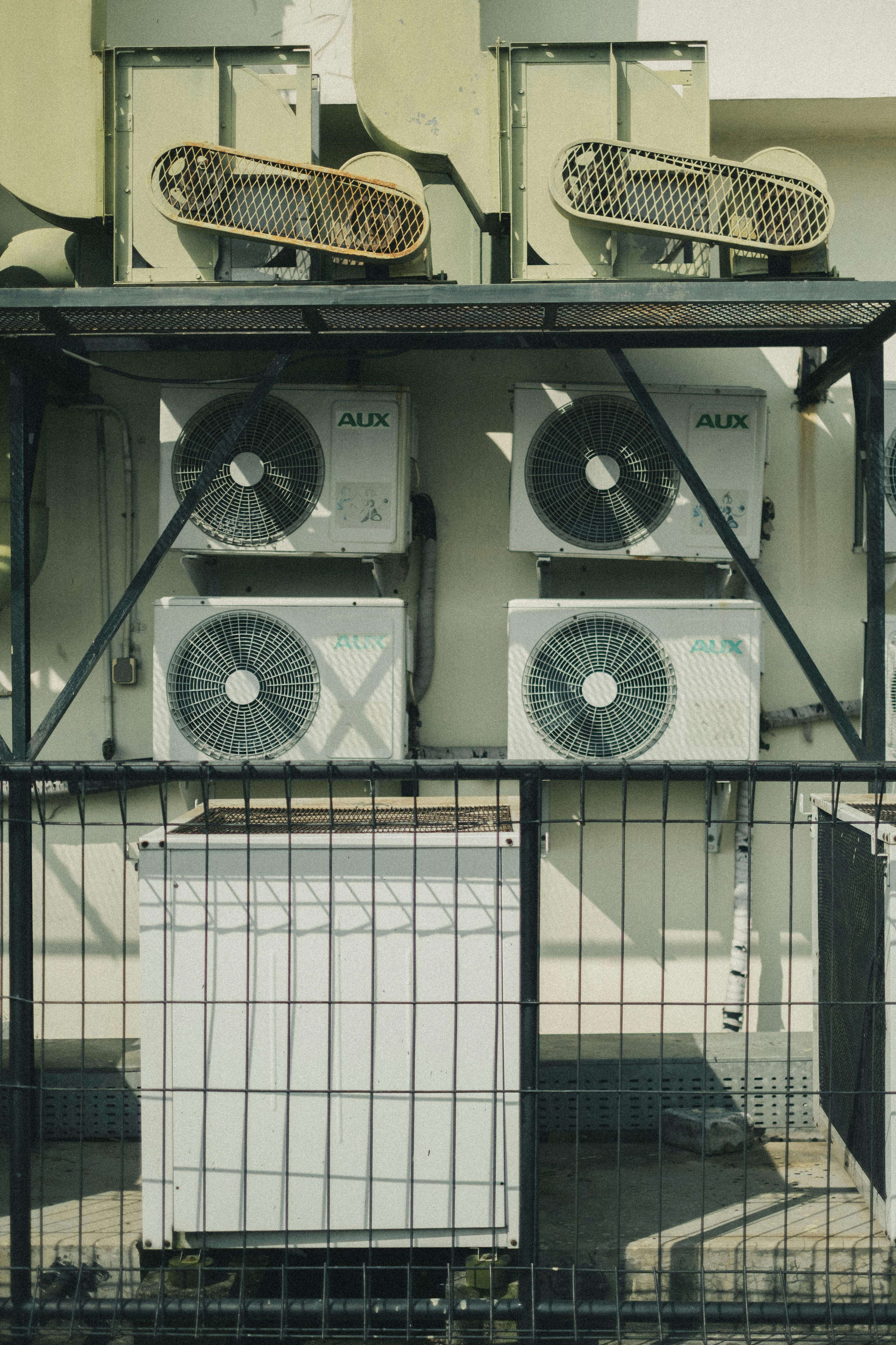 Multiple AUX brand HVAC units professionally installed on commercial building framework